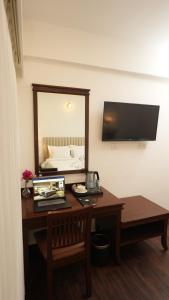 a room with a desk with a mirror and a bed at Ello Hotels in Bengaluru