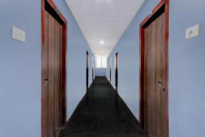 a hallway with wooden doors and white walls at Super Collection O Dr. NTR University Of Health Sciences Formerly Hotel V Elite in Vijayawāda