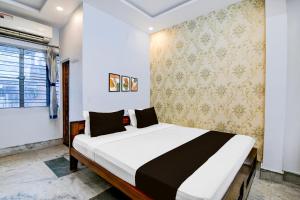 a bedroom with a large bed in a room at Super Hotel O Shalimar Railway Junction Formerly Tanima Villa 2 in Howrah