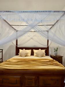 a bedroom with a bed with a canopy at Sasmika Villa Surf and Yoga Hostel in Weligama