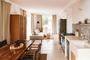 a kitchen and living room with a table and a couch at Boutique B&B Villa Gufo in Ostuni
