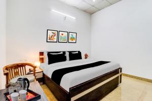 um quarto com uma cama grande e uma mesa em Super Hotel O Dehradun Central Railway Junction Formerly Bhagwan Guest House em Dehradun mais 25 fotografias