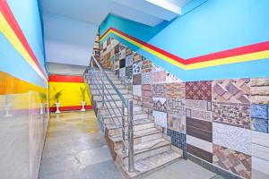 a staircase with colorful tiles on a wall at Super Hotel O Rishra Railway Station Formerly Green Guest House in Khardah