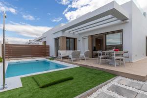 a villa with a swimming pool and a patio at Casa Henri in Orihuela