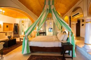 a bedroom with a bed with a canopy at Medieval Forts & Palaces in Pachār