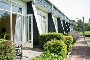 a house with a table and chairs outside of it at Hotel Beemster in Middenbeemster