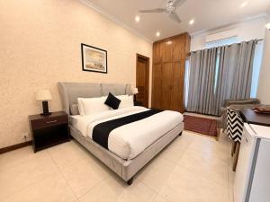 Un dormitorio con una cama y un escritorio. en Rhodium Hotel ONE, en Islamabad