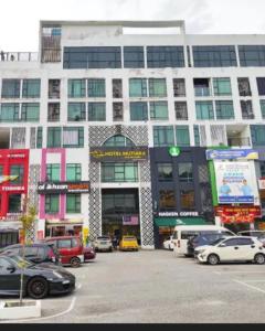 a large building with cars parked in a parking lot at D'Royale NH Homestay Kompleks Mutiara Gua Musang in Gua Musang