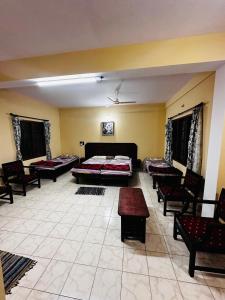 a large room with chairs and a bed in it at Aksha Inn in Madikeri