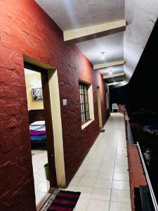 a hallway of a room with a red brick wall at Aksha Inn in Madikeri