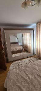 a mirror in a bedroom with a bed in it at Apartament in Rădăuţi