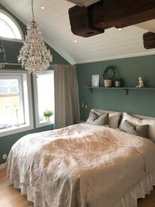 a bedroom with a large bed and a chandelier at Lev ut din Gårdsdröm! in Svängsta