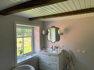 a bathroom with a sink and a mirror and a window at Lev ut din Gårdsdröm! in Svängsta +36 photos