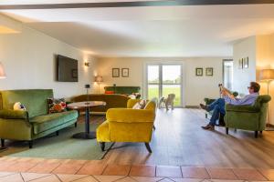 a living room with two people sitting in chairs at ibis Styles Chartres Sud Barjouville in Chartres