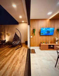 un salon avec une télévision sur un mur dans l'établissement Espaço LUHNA - Piscina - AR - Sauna Privativa, à Limeira