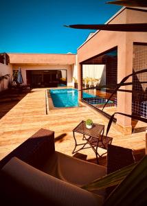 une arrière-cour avec une piscine et une table dans l'établissement Espaço LUHNA - Piscina - AR - Sauna Privativa, à Limeira 31 autres photos