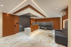 an office lobby with a reception desk and chairs at Hotel Rajshree Suites in Ujjain