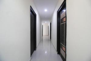 a hallway with black doors and white walls at Collection O Stayo in Hyderabad