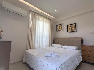 a bedroom with a bed with a towel on it at Anna's Seaside Apartment - In front of the beach in Kos Town