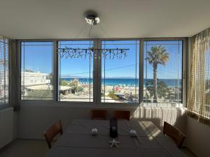 a dining room with a table and a view of the ocean at Anna's Seaside Apartment - In front of the beach in Kos Town