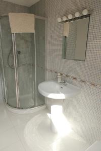 a white bathroom with a shower and a sink at Encanto Asturiano in Aller +15 photos
