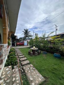 une cour avec une table et une pelouse dans l'établissement Subangan little Hawaii,6 Burgos Central location, à Burgos