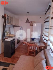 a living room with a couch and a table and a kitchen at Apartman Čeliković in Bosanski Šamac