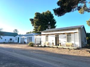 a white house with a porch on the side of a road at Rus n Bietjie Guest House in Loxton