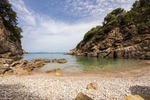 a beach with a rocky shore and the ocean at Relais Regina Giovanna in Sorrento