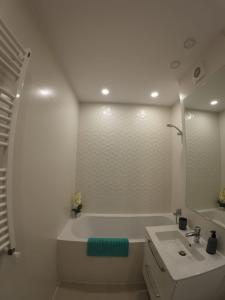 a white bathroom with a tub and a sink at Lovely Sunrise in Căţelu