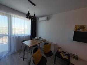 a room with a table and chairs and a window at Lovely Sunrise in Bucharest