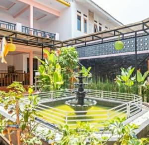 a fountain in the courtyard of a house at Puri Cikole Asri Guest House in Tangkubanperahu
