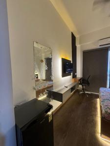a room with a bed and a desk and a mirror at Heavenly stays in Greater Noida