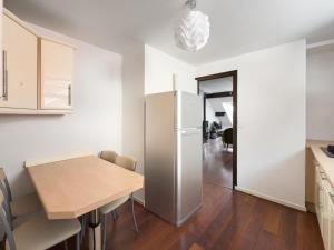 ヴェリエ・デュ・ラックにあるDuplex face au lac d'Annecyのテーブルと冷蔵庫のあるキッチン