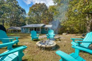 een tuin met blauwe stoelen en een vuurplaats bij Pennington Place Lookout Mtn in Rising Fawn