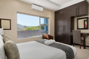 a bedroom with a bed and a desk and a window at 51 Dolphin Drive in Cape Town