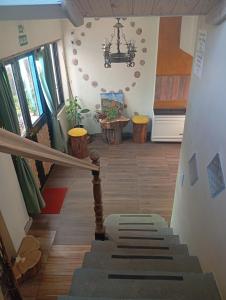 a staircase in a house with a chandelier at Hostel Plataforma Home in El Bolsón +2 photos