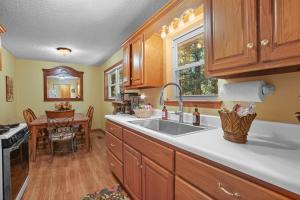 een keuken met houten kasten, een wastafel en een tafel bij Pennington Place Lookout Mtn in Rising Fawn