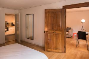 ツークにあるStylish Apartment in the Heart of Zug by Airhomeのベッド1台と木製のドアが備わる客室です。