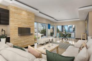 a living room with white furniture and a brick wall at 51 Dolphin Drive in Cape Town