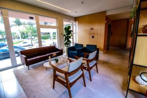 a living room with a couch and chairs and a table at MLG Hotel in Mogi das Cruzes