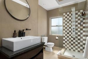 a bathroom with a sink and a toilet and a mirror at 51 Dolphin Drive in Cape Town +37 photos
