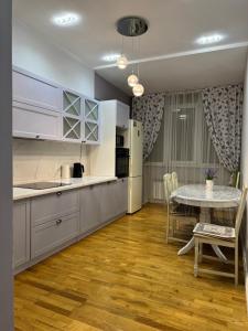 Una cocina con una mesa y un comedor. en Люкс 3 комнаты 105м2, en Karagandá