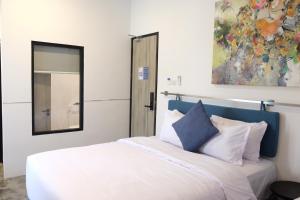 een slaapkamer met een wit bed en een spiegel bij Manta Rooms in Sentool
