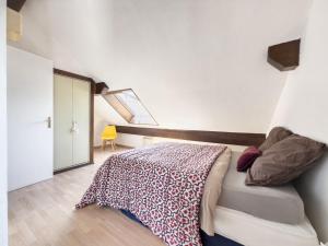 a bedroom with a bed with a blanket on it at Duplex face au lac d'Annecy in Veyrier-du-Lac