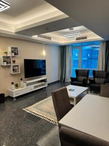 un salon avec une télévision, une table et des chaises dans l'établissement شقة فندقية كورنيش المعادي تاور ريزدنت 5, au Caire