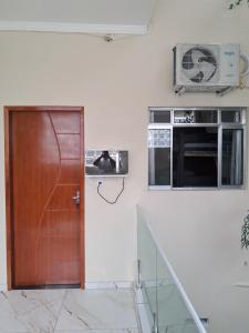 a wooden door in a kitchen with a microwave at Quarto2 banheiro privativo externo in Guarulhos