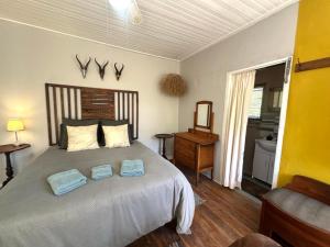 a bedroom with a large bed with two towels on it at Rus n Bietjie Guest House in Loxton
