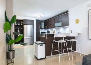 a kitchen with a counter and stools in a room at Aquaville Dorado Moderna Villa 3 in Dorado