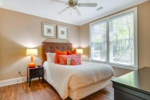 a bedroom with a bed with orange pillows and a window at Lake Oconee Creekside Condo with Dock Access in Liberty